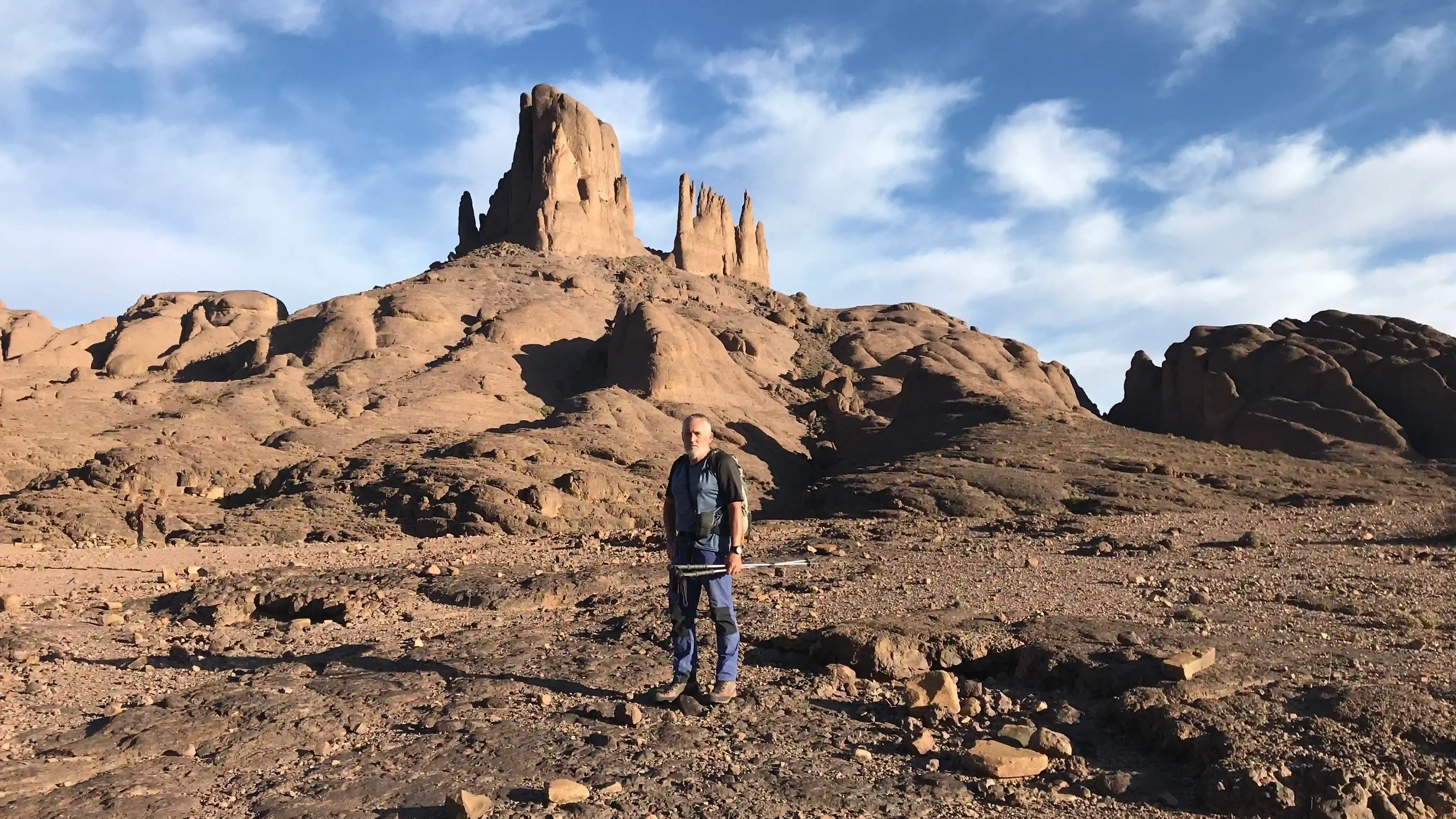 Trekking group climbing Toubkal summit with snowy Atlas peaks in background